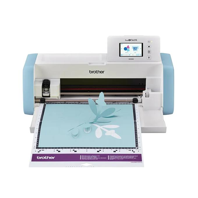 Brother ScanNCut DX cutting machine with touchscreen cutting floral design on blue mat