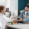 Customer presenting loyalty card to cafe employee using Brother handheld label maker