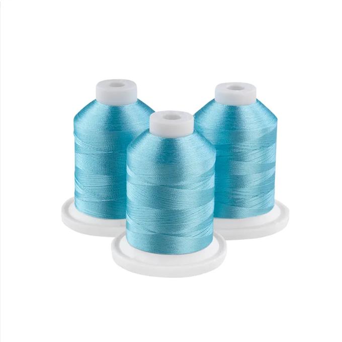 Three powder blue embroidery thread spools on white bases
