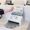 Brother desktop scanner with carrier sheet being inserted in modern office workspace