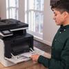 Person loading paper into Brother MFC-L8730CDW all-in-one color laser printer in home office