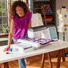 Woman using Brother Stellaire XJ2 quilting and embroidery machine with touchscreen in sewing studio