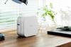 Brother P-touch Cube wireless label maker on desk with notebook and plants