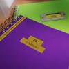Brother P-touch label on purple notebook with green spiral-bound planner