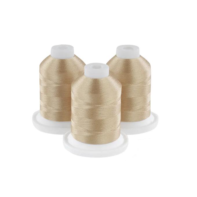 Three gold embroidery thread spools on white bases with white caps