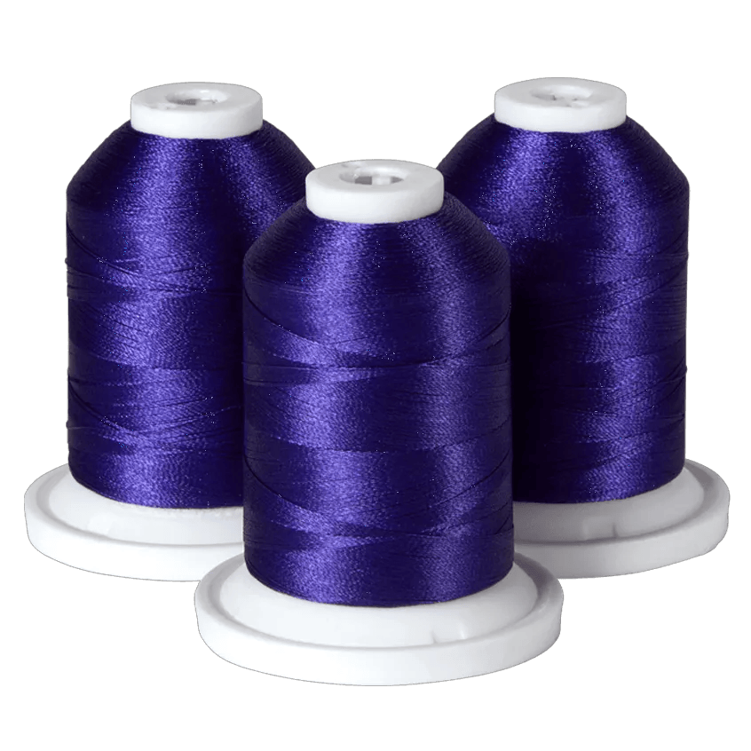 Three spools of purple Brother embroidery thread on white bases