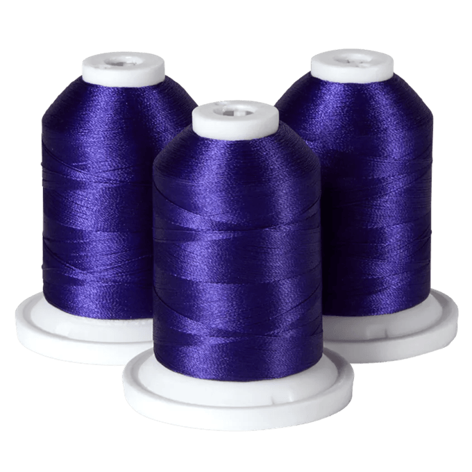 Three spools of purple Brother embroidery thread on white bases