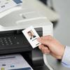 Hand scanning ID badge on Brother all-in-one color laser printer with wireless connectivity