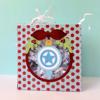 Festive gift bag with red polka dots, mustache decoration, and star ornament with shredded paper