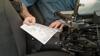 Law enforcement officer using Brother PocketJet mobile printer in vehicle
