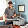 Man reviewing printed document from Brother monochrome laser all-in-one printer in home office