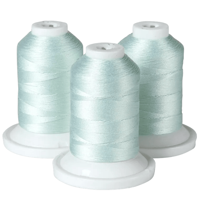 Three spools of light blue embroidery thread on white bases