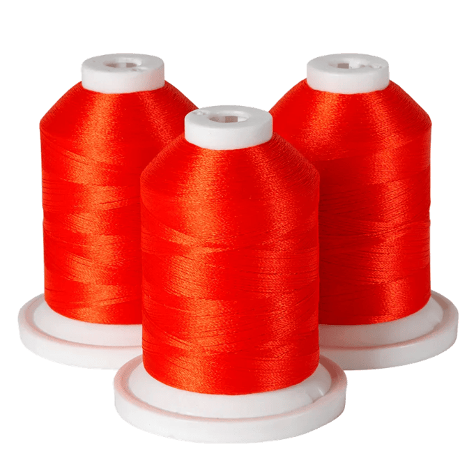 Three spools of bright red embroidery thread on white bases