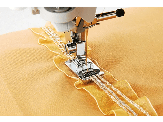 Brother sewing machine presser foot stitching decorative ruffled trim on golden fabric