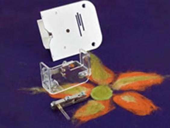 Brother sewing machine free-motion quilting foot with embroidered flower sample on purple fabric