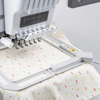 Brother embroidery machine with multi-needle system stitching patterned fabric in hoop