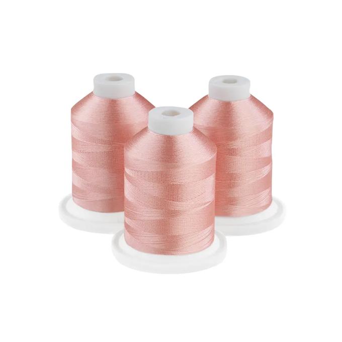 Three pink embroidery thread spools on white bases