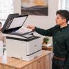 Man scanning documents on Brother MFC-L8930CDW color laser all-in-one printer in office