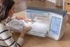 Woman using Brother Celeste sewing machine with touchscreen display for decorative stitching