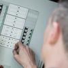 Hand adjusting settings on Brother laser printer control panel with buttons and display