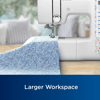 Brother sewing machine with blue floral fabric on wooden table in bright workspace