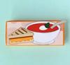 Grilled cheese sandwich with tomato soup enamel pin on mint background