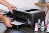 Persona cargando papel en impresora multifunción inalámbrica de tanque de tinta Brother DCP-T730DW