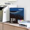 Brother TN331 3-pack toner cartridges next to laser printer in home office