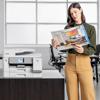 Woman reviewing color prints from Brother MFC-J6975DW all-in-one printer in modern office