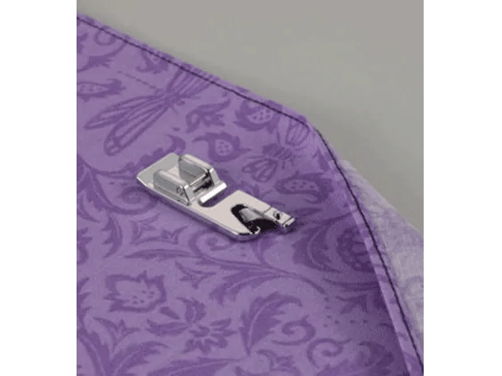 Brother sewing machine presser foot hemming purple fabric with decorative floral pattern