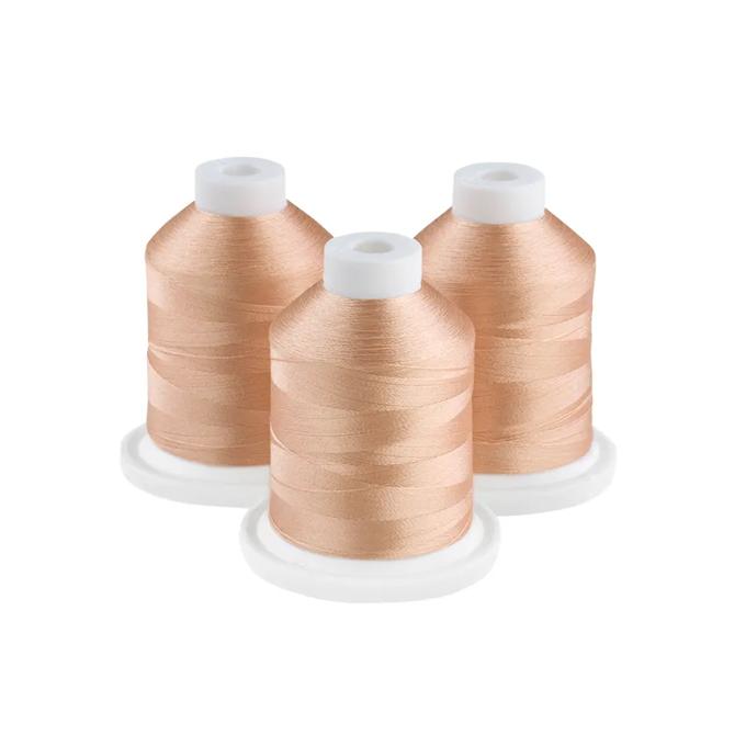 Three tan embroidery thread spools on white bases for sewing and crafting projects