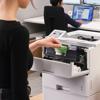 Woman replacing Brother toner cartridge in office laser printer