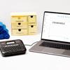 Brother P-touch label maker connected to laptop designing custom labels for wooden organizer