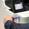 Hand inserting USB drive into Brother HL-L9410CDN color laser printer with touchscreen