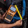 Brother PT-E560BT handheld label maker with QWERTY keyboard printing yellow cable labels