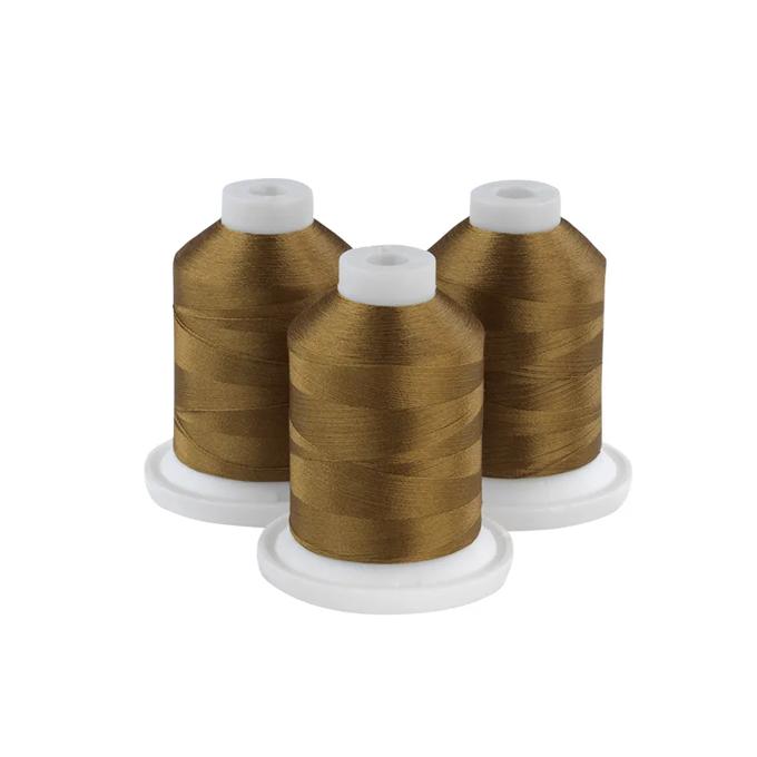 Three spools of gold embroidery thread on white bases