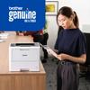 Woman reviewing printed document in office with Brother laser printer using genuine ink and toner