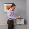 Professional using Brother HL-L6217DW monochrome laser printer in modern office environment