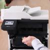 Brother all-in-one printer with toner cartridge being replaced by hand