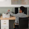 Person retrieving documents from Brother HL-L2865DW monochrome laser printer in home office