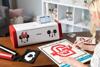 Woman using Brother SDX230Di cutting machine with Disney designs on home office desk