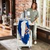Woman using Brother PR1X embroidery machine in home studio with blue fabric