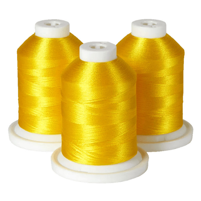 Three spools of golden yellow embroidery thread on white bases