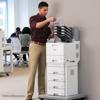 Man using Brother multifunction printer with paper trays in modern office workspace