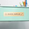 Brother laminated label on mint green storage drawer reading 'school supplies'