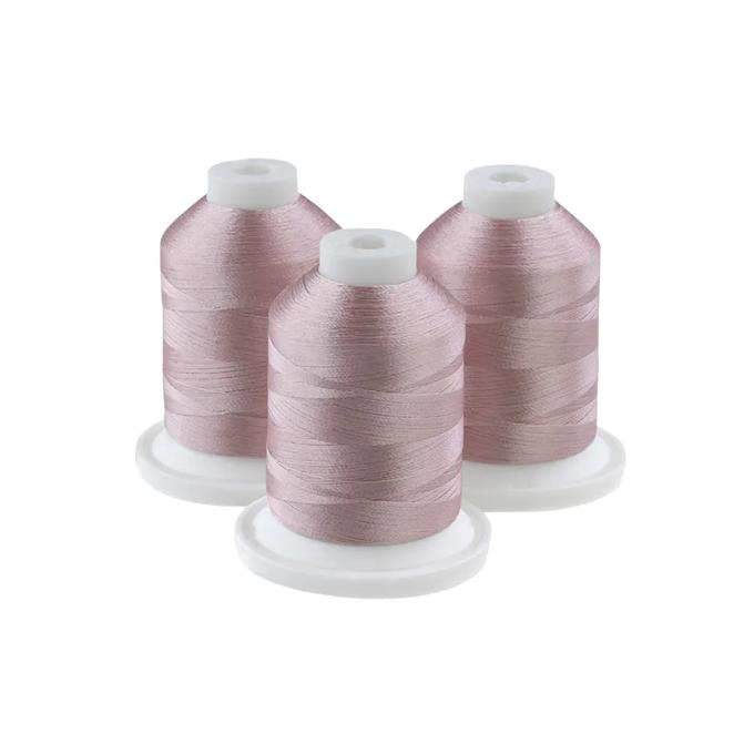 Brother embroidery thread spools in ecru pink on white cones