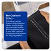 Hand holding black fabric with custom embroidery pattern near Brother sewing machine