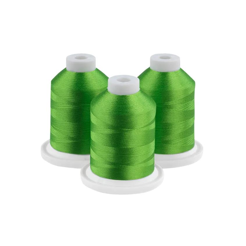 Three green embroidery thread spools on white bases
