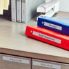 Brother label on red and blue binders for invoices and bank statements on office desk