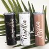 Three personalized insulated tumblers with lids and straws in black, marble, and rose gold